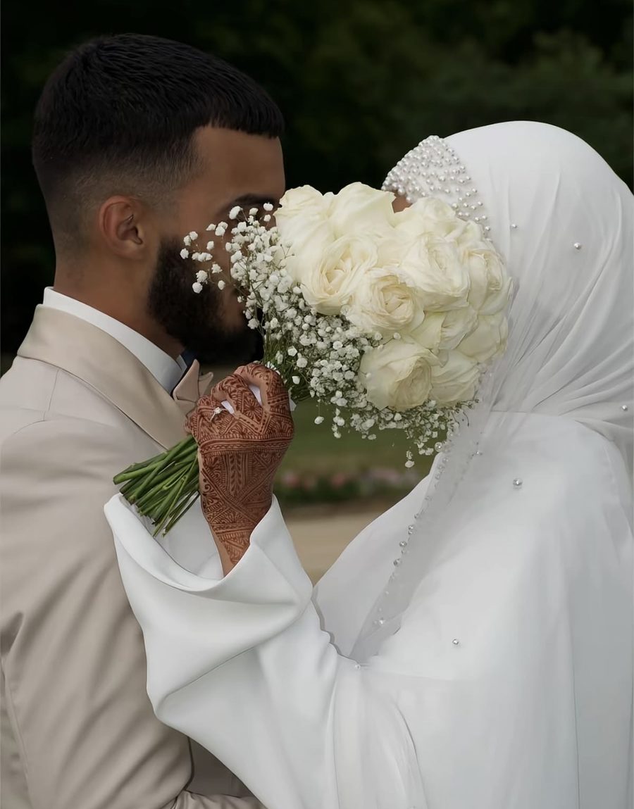 Mariés derrière un bouquet de roses blanches