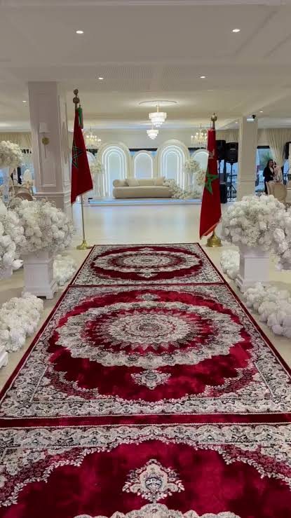 Salle de réception avec tapis rouge et fleurs blanches